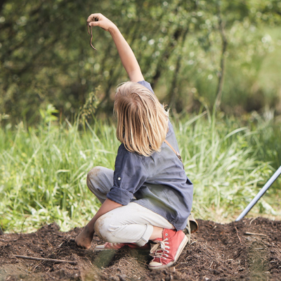 Jemand hält einen Regenwurm.