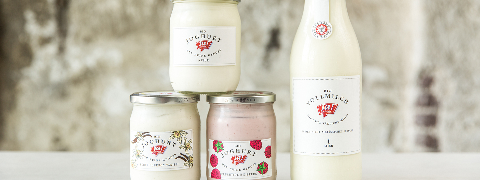 Verschiedene Ja! Natürlich Bio-Joghurte und eine Flasche Milch.