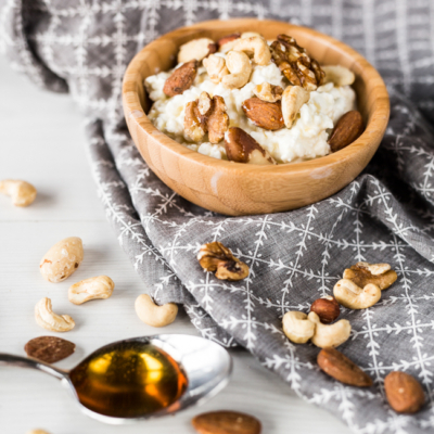 Eine Holzschüssel mit Bio-Cottage-Cheese und Nüssen.