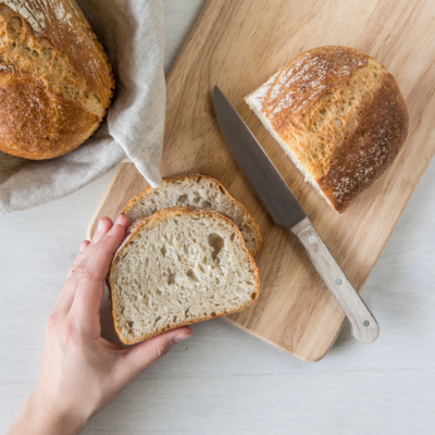 Jemand schneidet Bio-Brot.