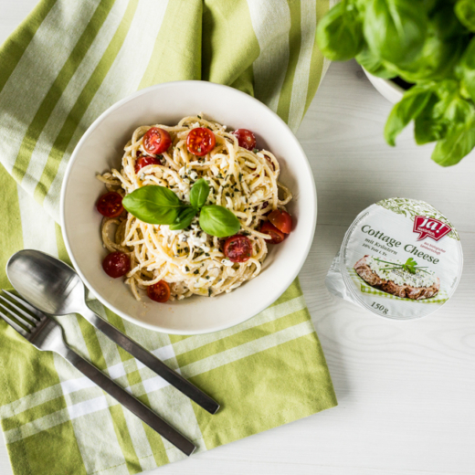 Eine Packung Ja! Natürlich Bio-Cottage Cheese mit Kräutern und Pasta in einer Schüssel.