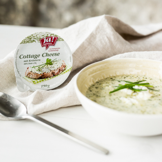 Eine Packung Ja! Natürlich Bio-Cottage Cheese mit Kräutern und Suppe in einer Schüssel.