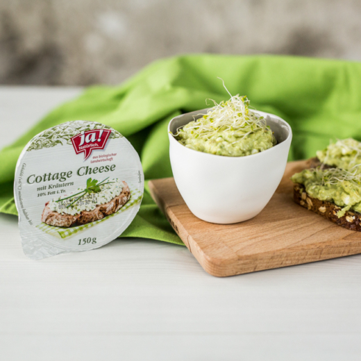 Eine Packung und eine Schüssel mit Ja! Natürlich Bio-Cottage Cheese mit Kräutern.