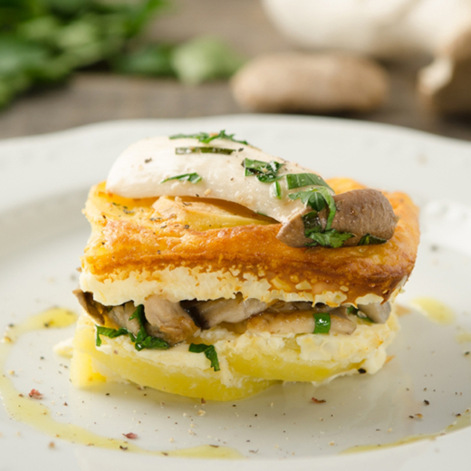 Ein Teller mit einem Stück Cottage-Cheese-Gratin mit Bio-Schwammerln.