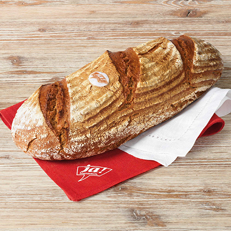 Ein Bio-Bauernbrot, umwickelt in einem Tuch.