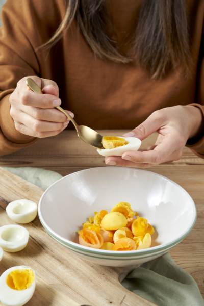Jemand entfernt den Dotter aus gekochten Bio-Eiern.