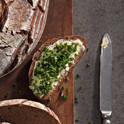 Ein Schnittlauchbrot neben einem Messer.