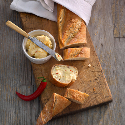 Aufgeschnittenes Bio-Baguette mit Chilibutter.