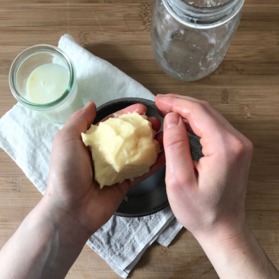 Jemand formt Butter in seinen Händen.