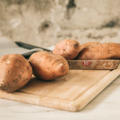 Ja! Natürlich Bio-Süßkartoffeln auf einem Schneidebrett.