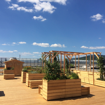 Bänke und Beete aus Holz auf der Dachterrasse.