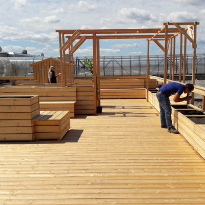 Bänke und Beete aus Holz auf der Dachterrasse.