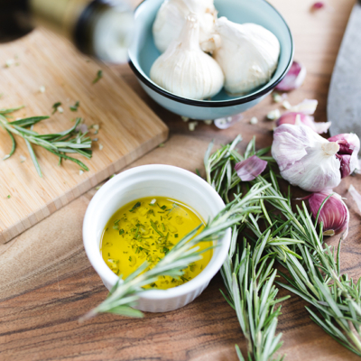 Eine Schale Bio-Olivenöl mit Rosmarin und Knoblauch.