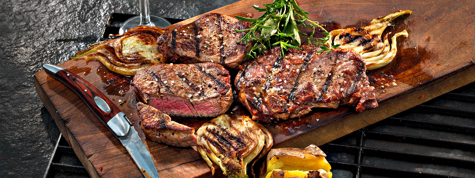 Gegrillte Bio-Steaks und Fenchel auf einem Holzbrett.