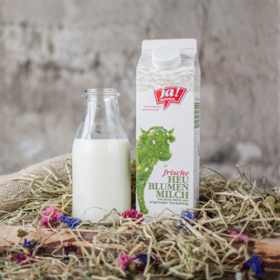 Ein Karton Ja! Natürlich Bio-Kuhmilch mit einer Glasflasche Milch.