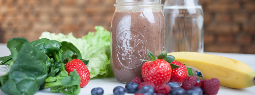 Bio-Smoothie umgeben von Früchten.